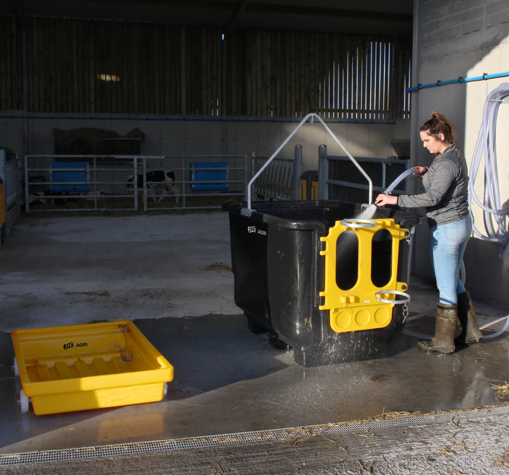 farmer washing Calf Isolation Unit