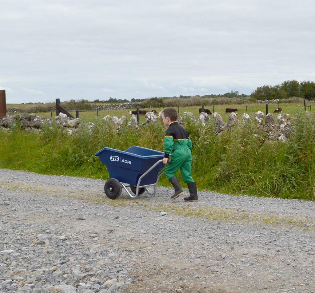 Junior Tipping Wheelbarrow (Blue) being pushed by child